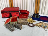 Overview of the lot showing all items: two onyx blank bars with fabric box, soapstone boxes, carved ox figures, bracelet, earrings, and red storage box.