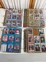 Four binders open showing various baseball cards, including players in action poses from the 1980s and 1990s.
