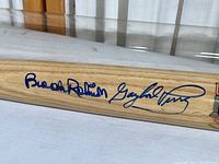 Close-up of the bat showing two blue ink autographs including Gaylord Perry's signature.