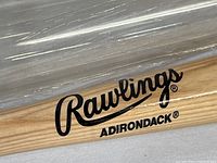 Close-up photo showing Rawlings and Adirondack logos on the bat's barrel, highlighting branding and condition of wood.