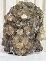 Front view of a large quartz mineral specimen showing numerous translucent, hexagonal crystals on rugged matrix base.