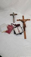 Photo showing entire lot including two crucifix crosses, rosary beads, and two pocket bibles on a white background.