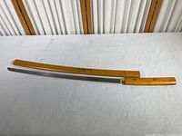 Full length view of the samurai sword replica with wooden scabbard, showing the blade and handle.