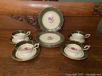 Tea and dessert set for four displayed showing cups on saucers and dessert plates behind.