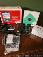 Photo showing multiple Blackberry phones, original boxes, cases, cords, and a USB flash drive laid out on a table.