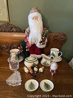 Full lot including Royal Crown Derby Santa, Spode creamer and sugar bowl, plates, glass, crystal tree decoration, and four figurines on skewers on a wooden table