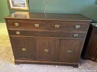 Front view of solid wood sideboard with four drawers and two cabinet doors, showing brass pulls and overall finish.