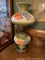 Photo showing the full lamp including the floral glass sections and ornate metal base.