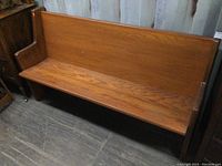 Front view of wooden church pew showing seat and back