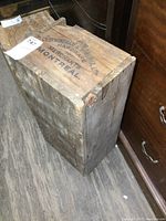 Wooden crate showing overall exterior condition, size, and structure with aged wear and cracking on wooden panels.