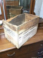Angle view of antique wooden Forcite crate showing finger jointed corner with some missing wood and stenciled branding and safety labels.