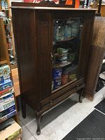 Full view of antique walnut china cabinet showing glass door and carved details