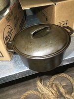 Side view of the cast iron Dutch oven with lid on, showing handles and overall shape.