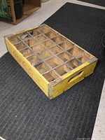 Top view of vintage Coca-Cola wooden bottle crate showing the 24 bottle compartments and handles on the sides.