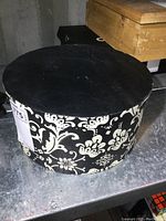 Single black and white floral patterned hat box with lid