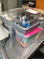 Two small totes plus a clear container with assorted LEGO parts including bricks and small pieces.