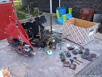 Three assembled Mega Bloks Pirates of the Caribbean ships displayed on a table with loose blocks and accessories scattered around.