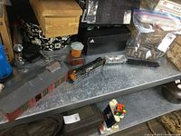 Overview of the vintage CN train engine with two rail cars, red building of about 11.5 inches, orange silo, track pieces, and extra small items on metal surface.