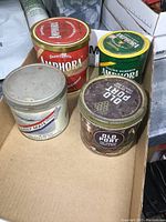 Photo of lot showing all four vintage metal tins on a cardboard surface, including two Douwe Egberts Arabora coffee tins (red and green), Old Port tobacco tin, and Daily Mail cigarette tobacco tin.