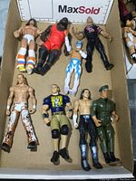 Eight wrestling action figures arranged in a cardboard box, showing overall condition and variety of figures.