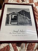 Frontal view of framed black and white photographic print of Taos Pueblo Church by Ansel Adams showing the subject and matting.
