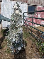 Full view of 6-foot artificial Christmas tree outdoors, showing overall decorations and tree shape