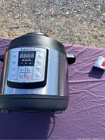 Instant Pot Lux Mini electric pressure cooker angled side view showing digital control panel and stainless steel body