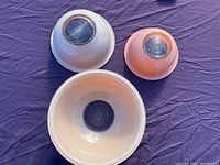 Three mixing bowls shown upside down displaying their bases, with color variations identifiable.