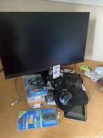 Photo of the HP 24-inch monitor, cords, iPads, mice, keyboard, and unopened computer accessories on a wooden surface