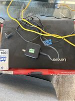 Top view of Lenovo laptop with power adapter and cables on top of it.