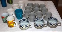 Photo showing all 19 cups including 10 grey Calvin Klein pottery cups, 3 ceramic bowls, 2 museum cups, and 4 large mugs.