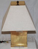 Lamp with beige shade on, showing full front view.