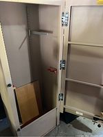 Interior view with door open showing adjustable shelf brackets and hanging bar