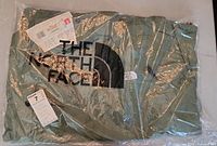 The North Face light parka sealed in plastic packaging