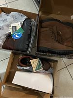 Photo showing three pairs of men's boots in their boxes, brown leather, tan suede Gore-Tex, and dark brown boots with PermaSeal tag.
