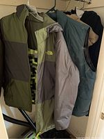 Photo showing North Face winter coat with olive and grey color blocks and pixel pattern inner lining