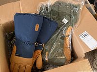 Photo showing a pair of navy blue and brown Gore-Tex gloves beside green gloves in a box