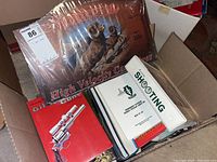 Wide view of the box contents showing books and wall sign