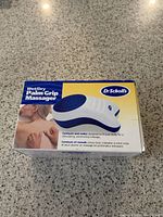 Dr. Scholl's Wet/Dry Palm Grip Massager in original packaging showing product image and brand information.