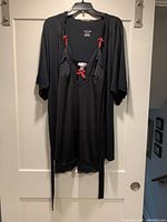 Black nightgown and robe set hanging on hanger, clearly showing lace trim and pink bows on nightgown straps and front.