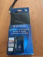 Front view of travel organizer in original packaging showing card slots and passport holder illustration