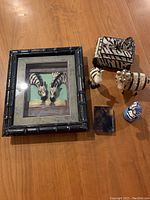 Overview photo showing all lot contents: framed 3D zebra picture, zebra box, and four animal figurines.