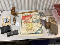 Overview of all items on a table showing books, stereoscopic viewfinder, map, and ephemera.