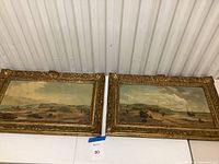 Both paintings side by side on table, full view of lot