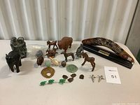 Full lot view of assorted brass, wooden, jade, ceramic, metal figurines and decor, also includes Aboriginal art boomerang.