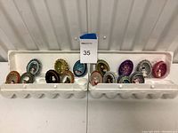 Wide view of all glittery decorative eggs arranged in two egg cartons, showing the variety of colors and trims.