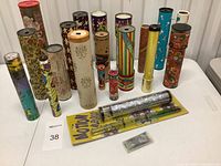 Wide view of full collection of vintage kaleidoscopes showing various designs and sizes arranged on a table