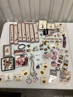 Overall assortment of patriotic costume jewelry including necklaces, pins, bracelets, pendants, and other small accessories arranged on a table.