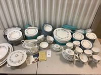 Full overview: stacks of plates, bowls and assorted tea service on table