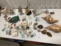 Overview of entire lot on white table; dozens of shells and decor pieces visible